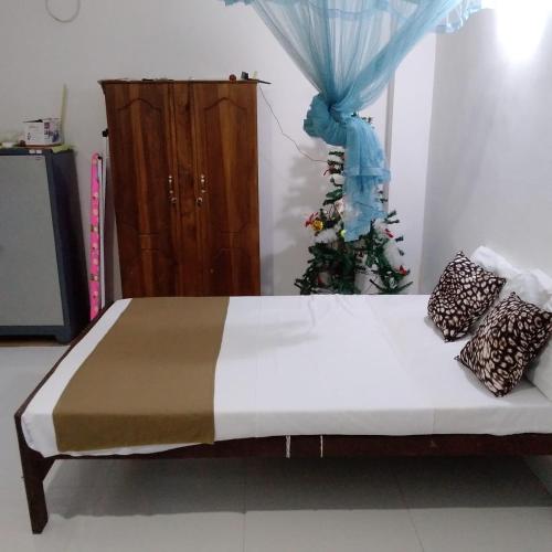 a bed in a room with a blue curtain at Sanduhan Villa in Warakapola