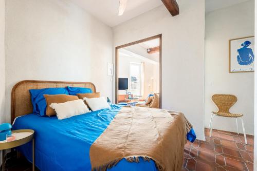 - un lit bleu dans une chambre avec un miroir dans l'établissement Captain Watch - vue sur le port & les bateaux - Parking souterrain offert, à La Ciotat