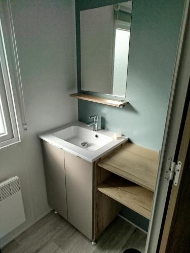 une salle de bain avec un lavabo et un miroir dans l'établissement Mobil-home 3 chambres, à Saint-Jean-de-Monts