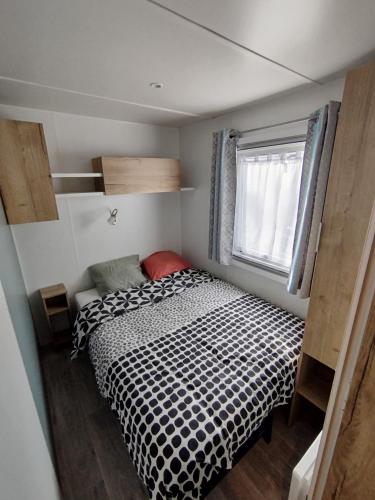 - une petite chambre avec un lit noir et blanc dans l'établissement Mobil-home 3 chambres, à Saint-Jean-de-Monts