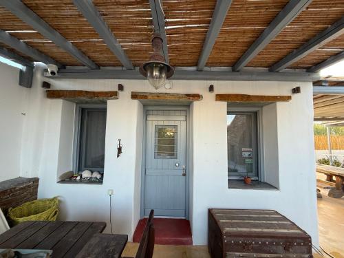 a porch with a blue door and a wooden ceiling at Nefeli in Livadion
