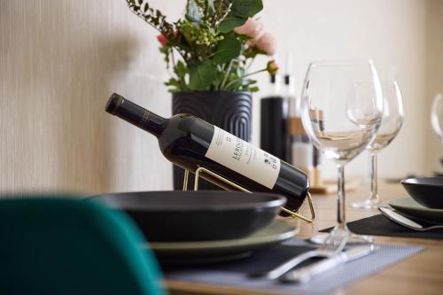 a bottle of wine sitting on a table with glasses at Apartment bei Nürburgring, Parking, Homeoffice in Blankenheim