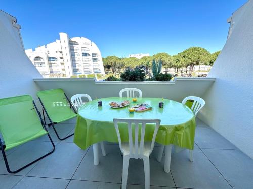 a table and chairs on a balcony with a view of a building at Les Petits Bateaux-Parking privé-Terrasse in La Grande-Motte