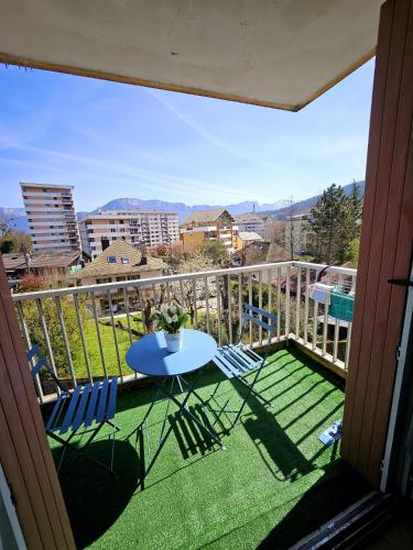 un patio avec une table et des chaises sur un balcon dans l'établissement Paradise Apartment near downtown lake & Free Parking - local bike, à Annecy