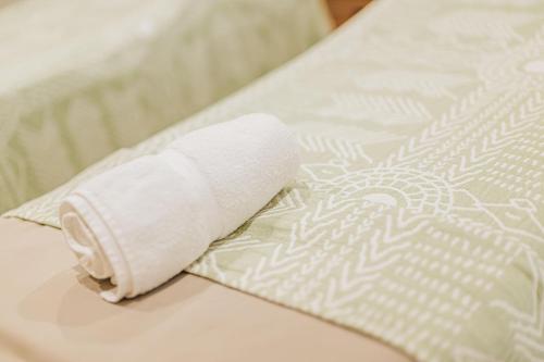 a roll of toilet paper sitting on a bed at Eva Spa Resort Rooftop Pool 1br By Lucha in Savaneta