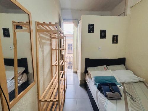 een kleine kamer met een bed en een spiegel bij Pequena Suíte Individual 304 in Rio de Janeiro