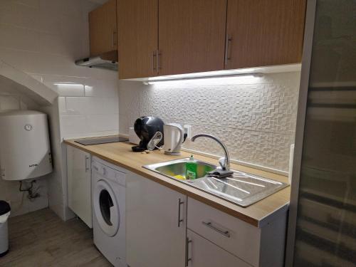a kitchen with a sink and a washing machine at Casa da Judiaria in Évora