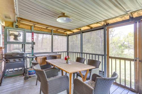 a screened in porch with a wooden table and chairs at 6 Mi to Ellen Trout Zoo Family Home with Yard! in Lufkin