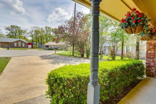 a pole with a flower pot on it next to a hedge at 6 Mi to Ellen Trout Zoo Family Home with Yard! in Lufkin