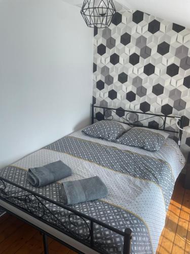 a bedroom with a bed with a black and white headboard at Escapade poitevine - Maison climatisée avec 3 Ch - 4 min Futuroscope et Aquascope in Chasseneuil-du-Poitou
