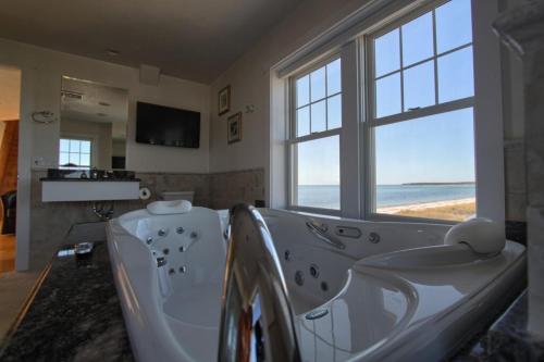a bathroom with a tub with a view of the ocean at West Yarmouth - Luxury Oceanfront Vacation Home in Yarmouth