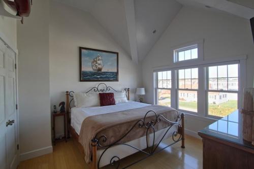 a bedroom with a bed and a large window at West Yarmouth - Luxury Oceanfront Vacation Home in Yarmouth