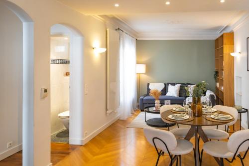 un salon avec une table, des chaises et un canapé dans l'établissement Spacious Apartment for 6 People, à Paris