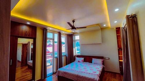 a bedroom with a bed and a ceiling fan at Dhauladhar Vista in Pālampur