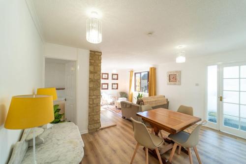 a living room with a wooden table and chairs at Bumble Bee Bungalow Serviced Accommodation in Witney