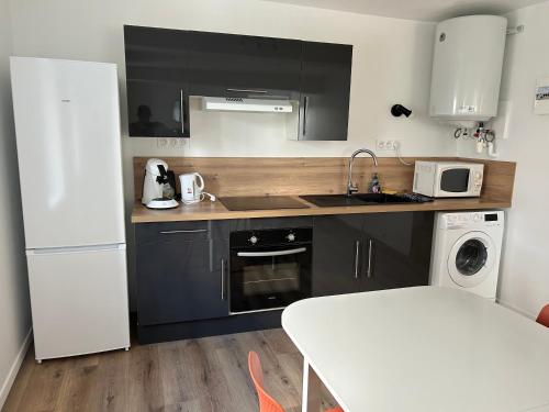 una cucina con un lavello e un frigorifero bianco di Charmant appartement au cœur de Montrond a Montrond-les-Bains