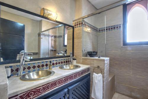 a bathroom with two sinks and a large mirror at VILLA Garden in Marrakesh