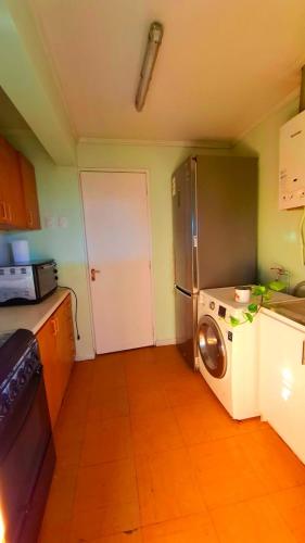 a kitchen with a refrigerator and a washing machine at Casa Terracota in Chillán