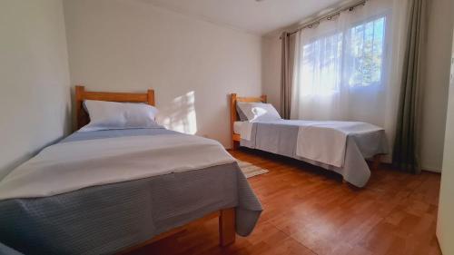 a bedroom with two beds and a window at Casa Terracota in Chillán