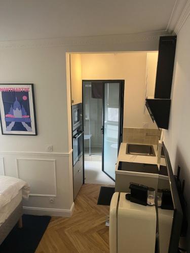 Cette petite chambre comprend une cuisine et un lit. dans l'établissement Flat in heart of Paris, à Paris