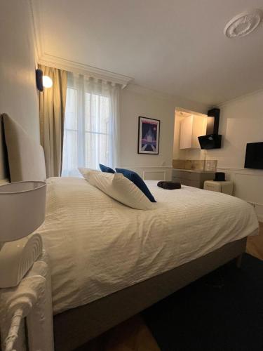 une chambre avec un grand lit blanc avec une fenêtre dans l'établissement Flat in heart of Paris, à Paris