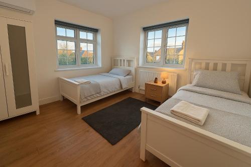 Un dormitorio con dos camas y dos ventanas. en Beautiful 5 bedroom house in central london, en Londres