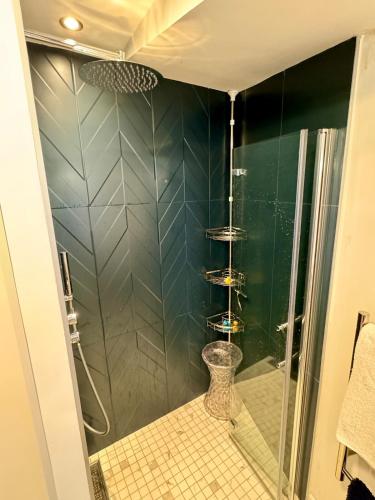 une salle de bain avec une douche avec une porte vitrée dans l'établissement Oasis de confort aux portes de Lyon avec jardin privé, à Oullins