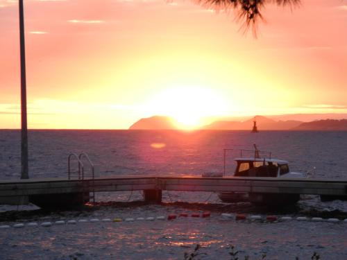 a boat in the water with the sunset in the background at Gorgeous apartment Dora in Cavtat