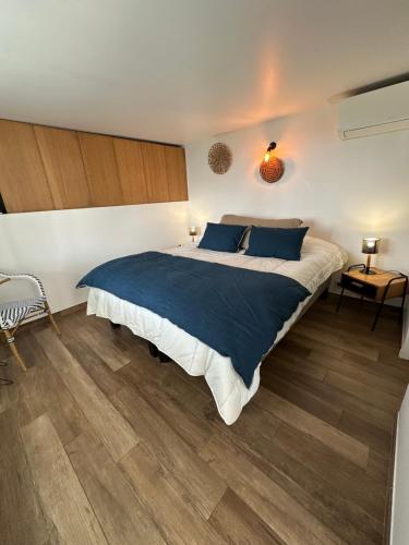 a bedroom with a large bed and wooden floors at Home Cassis - Maison Méditerranée - Piscine chauffée à 30c in Cassis