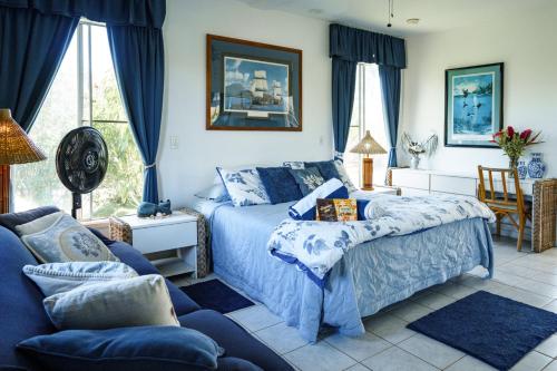 a bedroom with a blue bed and a couch at Lanai Villas in Koloa