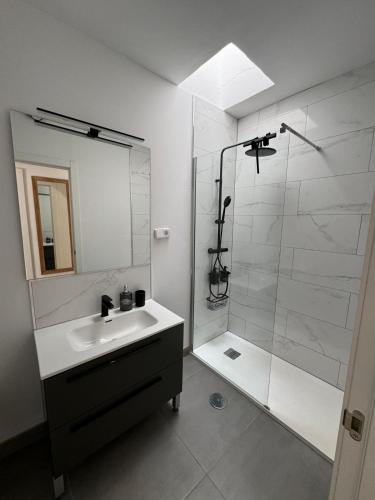 a white bathroom with a sink and a shower at Casa Limon in Cartagena