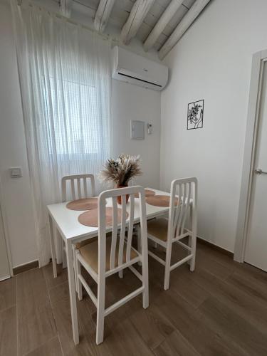 een witte eetkamer met een tafel en stoelen bij Casa Peñas 2 in Ronda