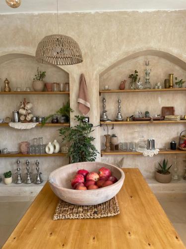 a bowl of apples on a table in a kitchen at Meddur Siwa Oasis in Siwa