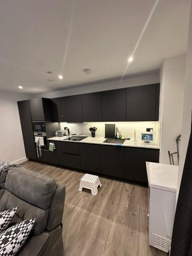 a living room with a couch and a kitchen at Panoramic Private Room and Bathroom in a Modern Apartment in Croydon