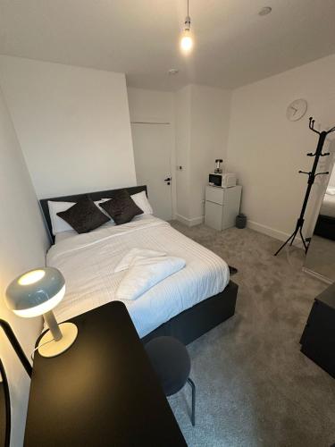a bedroom with a bed and a desk and a chair at Panoramic Private Room and Bathroom in a Modern Apartment in Croydon