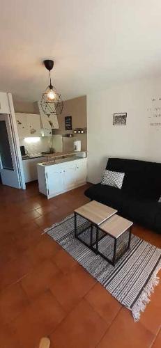 un salon avec un canapé et une table basse dans l'établissement studio cabine La Cantarelle rez de chaussée, à Bandol