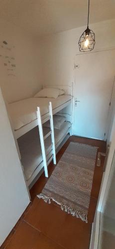 Cette petite chambre comprend 2 lits superposés et un tapis. dans l'établissement studio cabine La Cantarelle rez de chaussée, à Bandol
