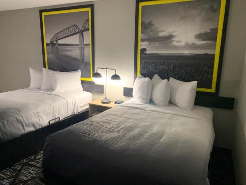 a hotel room with two beds and a picture of a bridge at Super 8 by Wyndham Kirksville-University Area in Kirksville