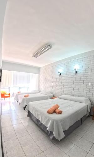 a bedroom with three beds in a room at Hotel Qamiri in Arica