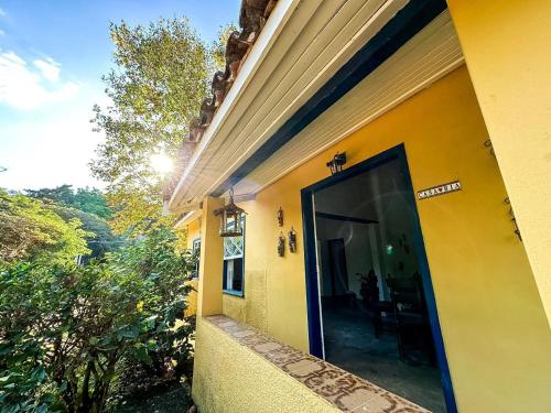 a yellow building with a large door on the side at Fazenda Santa Thereza - Itapira in Itapira