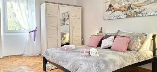 a bedroom with a bed with pink and white pillows at Calma di Medulin in Medulin