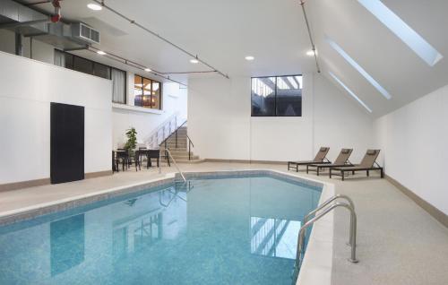 a swimming pool with chairs and a table in a building at AC Hotel Frisco Colorado in Frisco