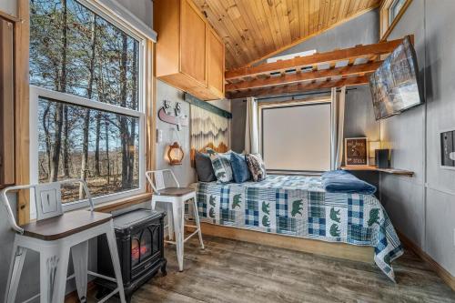a bedroom with a bed and a desk and a window at Tiny Cub House with Fast WiFi and Dog Friendly in Mentone