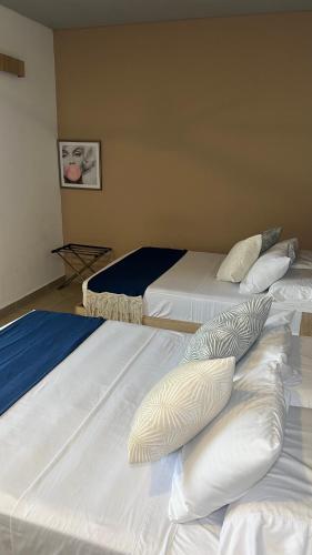 a group of three beds in a room at Star AV 37 HOTEL in Ibagué