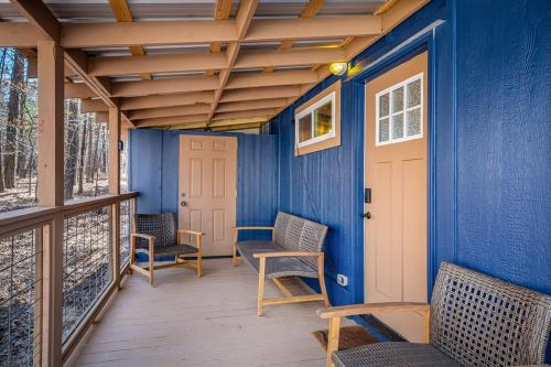 a porch with chairs and a blue wall at Tiny Cub House with Fast WiFi and Dog Friendly in Mentone