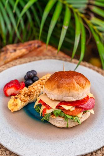 a sandwich on a plate with fruit and pretzels at Traveler Hostel in San Gil