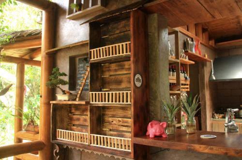a kitchen with a wooden wall with a shelf at La Bicok EcoLodge in Mindo