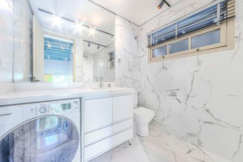 ein weißes Bad mit einer Waschmaschine und einem Trockner in der Unterkunft Relaxing & Modern House - Walking Distance from Historic Center of Paraty in Paraty