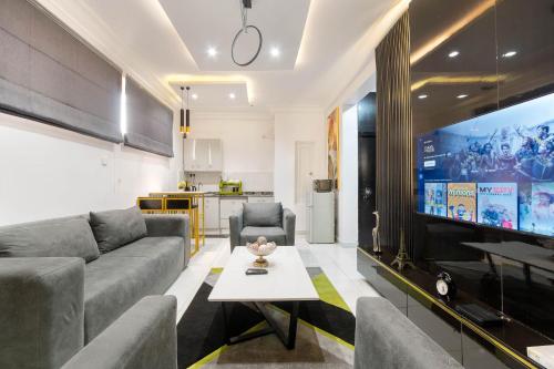 a living room with a couch and a large tv at 2 bedroom Luxury Shortlet Apartment in Osapa London, Lekki in Lagos