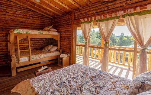 a bedroom with two bunk beds and a balcony at Eco Hotel Nigüíto in Medellín